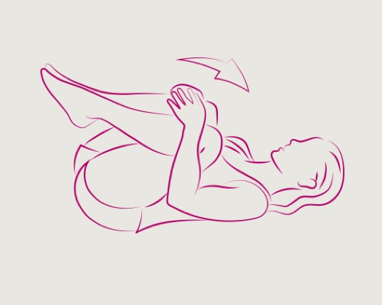 Moteris, gulinti ant žemės ir, apkabinusi rankomis, spaudžianti kelius krūtinės link, kad vyktų tempimas.